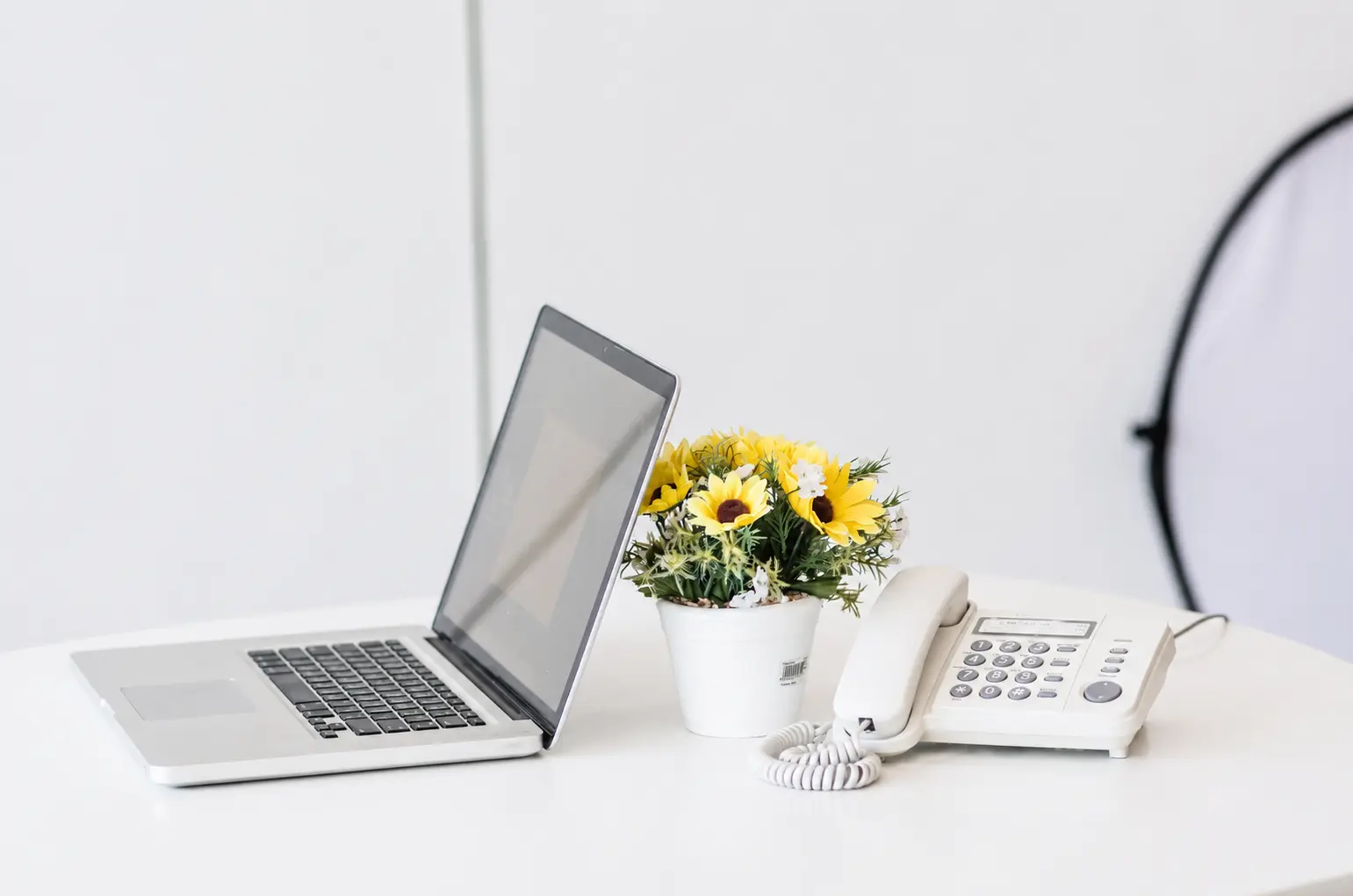  A laptop and smartphone placed on a white table, symbolizing digital communication and online connectivity.